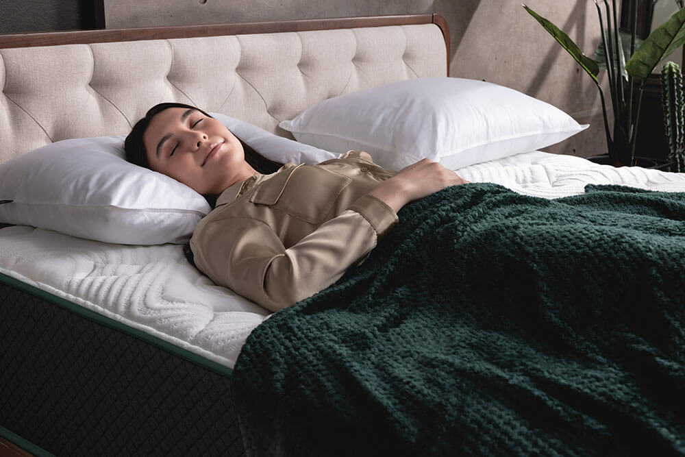 Woman resting on her back on a Logan & Cove Choice mattress with Down Alternative Pillows