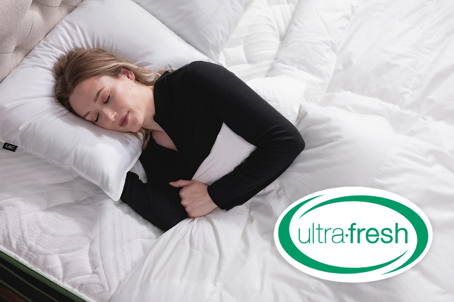 Woman sleeping in bed under Canadian Down Duvet with superimposed Ultra-Fresh® logo