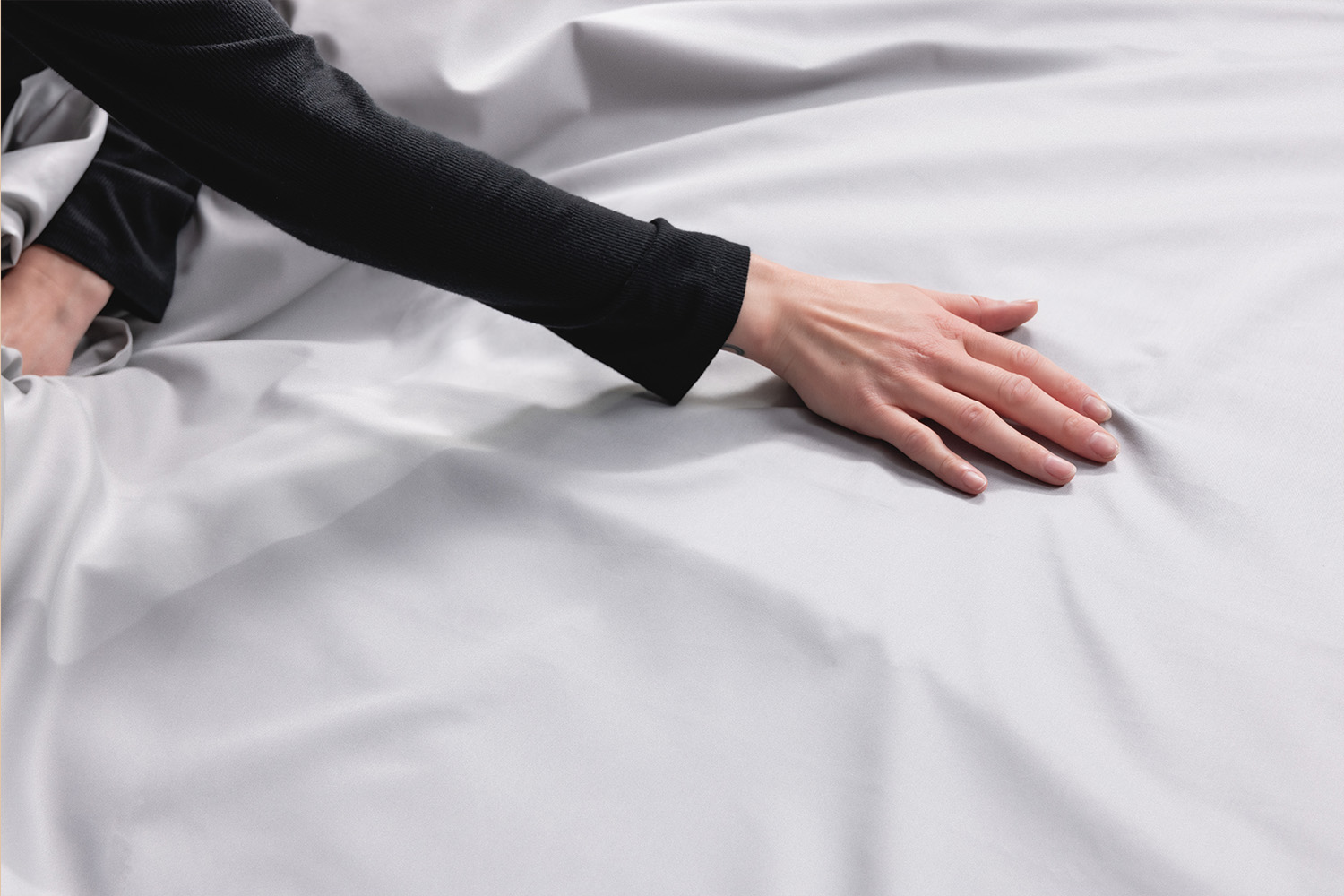 Woman smiling and touching Egyptian Cotton Sheets to her face
